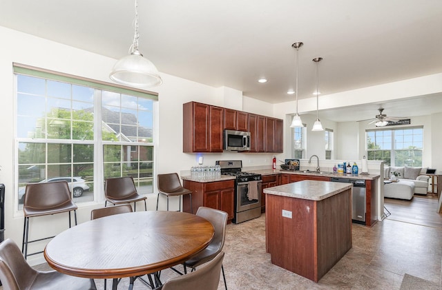 15373 Sheffield Square Pkwy, Orland Park, IL 60462 - kitchen featuring stainless steel appliances, a peninsula, a center island, light countertops, and a ceiling fan