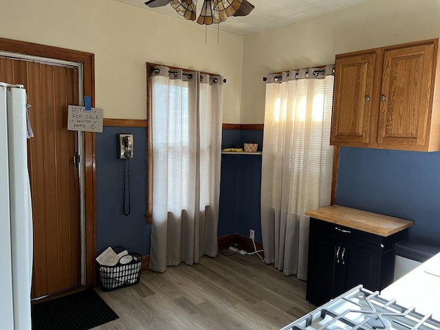 4721 W Warwick Ave, Chicago, IL 60641 - kitchen featuring freestanding refrigerator, a ceiling fan, light wood finished floors, brown cabinets, and dark cabinets