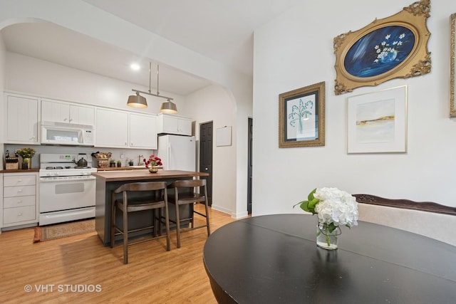 5747 W Grace St, Chicago, IL 60634 - dining area with arched walkways and light wood finished floors