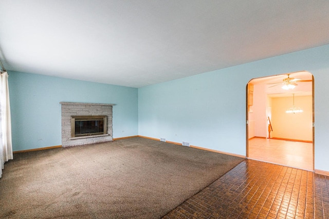 525 Bunning Dr, Downers Grove, IL 60516 - unfurnished living room featuring a stone fireplace, arched walkways, and a chandelier