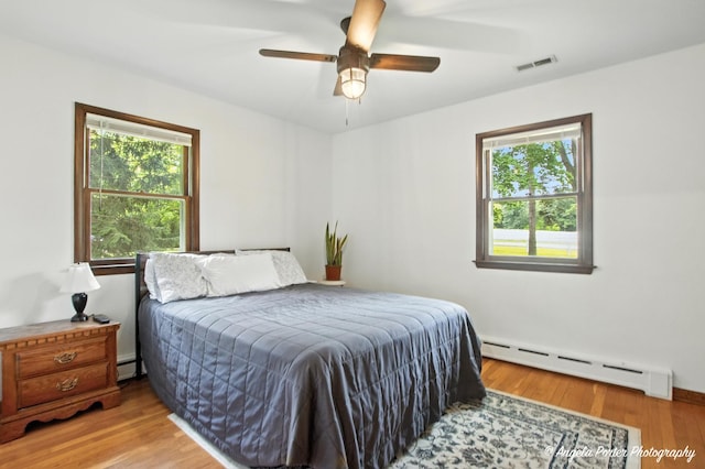 2514 Cuhlman Rd, Mchenry, IL 60051 - bedroom featuring a baseboard radiator, multiple windows, wood finished floors, and a baseboard heating unit