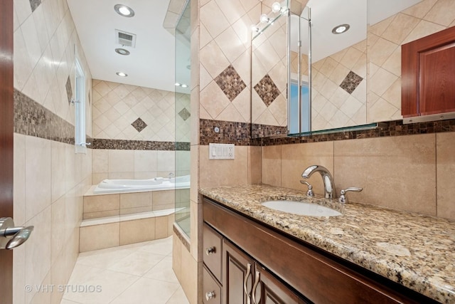 36 Logan Ter, Golf, IL 60029 - full bathroom featuring tile walls, tiled tub, vanity, tile patterned flooring, and tiled shower