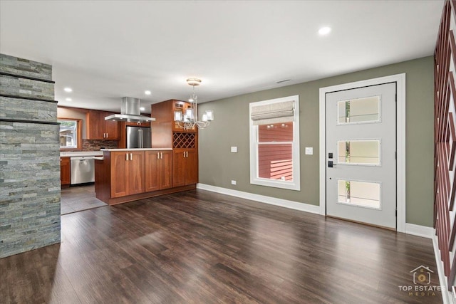 1702 Winthrop Ln, Schaumburg, IL 60193 - kitchen featuring appliances with stainless steel finishes, island range hood, a chandelier, brown cabinetry, and tasteful backsplash