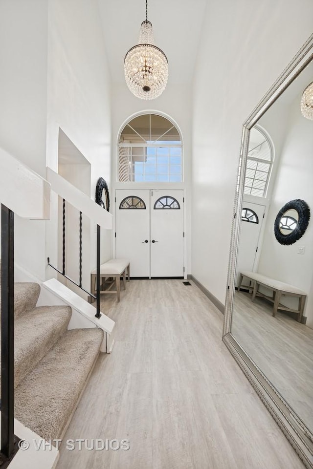 707 Sturnbridge Ln, Schaumburg, IL 60173 - foyer with high vaulted ceiling, a chandelier, wood finished floors, and stairway