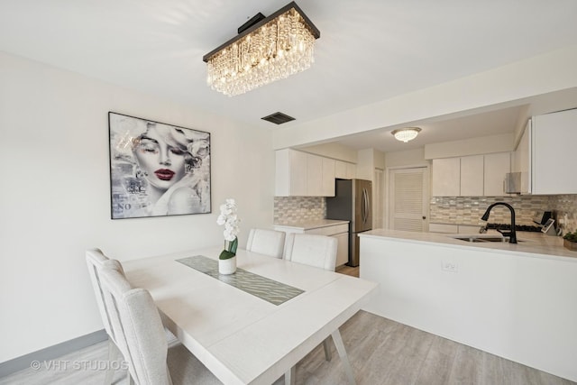 707 Sturnbridge Ln, Schaumburg, IL 60173 - dining room featuring light wood-type flooring and a chandelier