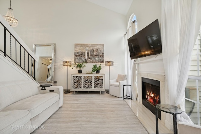 707 Sturnbridge Ln, Schaumburg, IL 60173 - living area featuring high vaulted ceiling, wood finished floors, stairway, a lit fireplace, and a chandelier