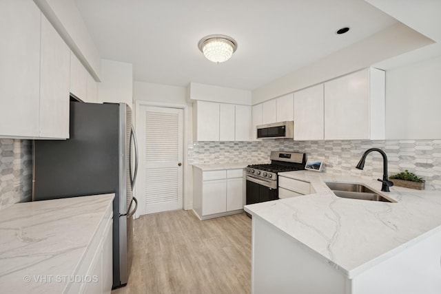 707 Sturnbridge Ln, Schaumburg, IL 60173 - kitchen with stainless steel appliances, light stone countertops, decorative backsplash, light wood-style flooring, and a peninsula