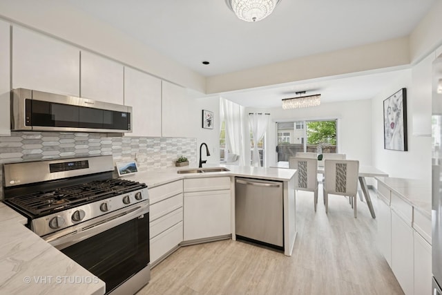 707 Sturnbridge Ln, Schaumburg, IL 60173 - kitchen with appliances with stainless steel finishes, light wood-style floors, and light countertops
