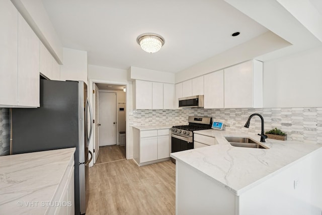 707 Sturnbridge Ln, Schaumburg, IL 60173 - kitchen featuring stainless steel appliances, decorative backsplash, light stone countertops, light wood finished floors, and a peninsula