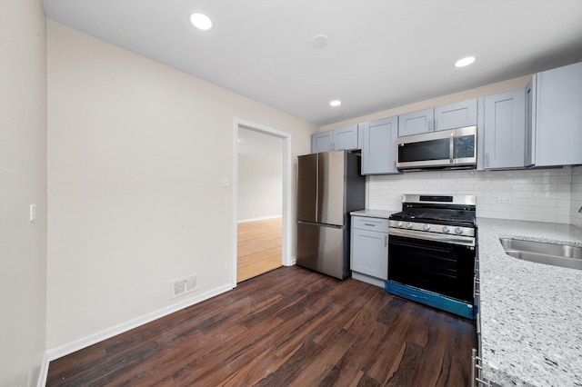 476 W 17th St, Chicago Heights, IL 60411 - kitchen featuring appliances with stainless steel finishes, dark wood finished floors, tasteful backsplash, light stone counters, and recessed lighting