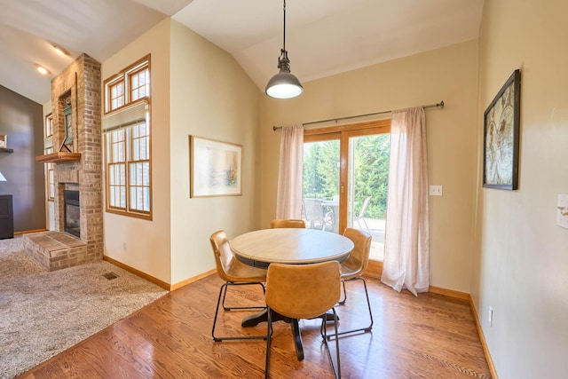 671 Teal Ct, Dekalb, IL 60115 - dining area with lofted ceiling, a brick fireplace, and wood finished floors