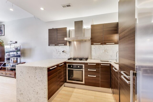 1811 W 17th St Unit 201, Chicago, IL 60608 - kitchen with stainless steel appliances, wall chimney exhaust hood, a peninsula, tasteful backsplash, and recessed lighting