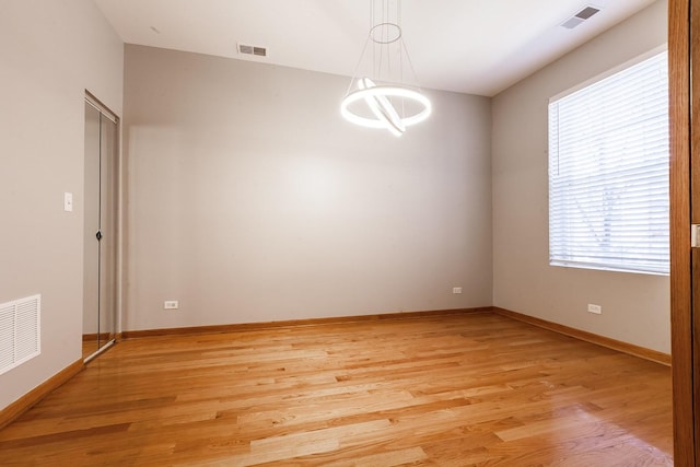 4137 S Prairie Ave Unit 1S, Chicago, IL 60653 - spare room featuring light wood finished floors and a chandelier