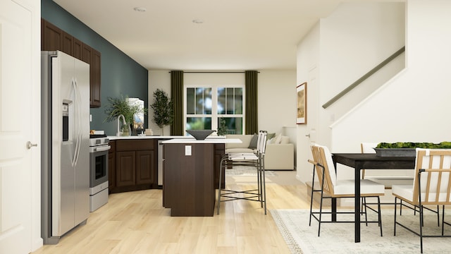 2103 Neubauer Cir, Lindenhurst, IL 60046 - kitchen with appliances with stainless steel finishes, a breakfast bar, light wood-type flooring, light countertops, and dark brown cabinetry