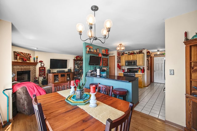 5613 W Von Ave, Monee, IL 60449 - dining area featuring a chandelier, a fireplace, and light wood-type flooring