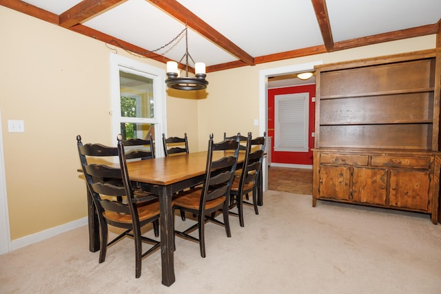 24503 Iroquois Ln, Hudson, IL 61748 - dining space featuring light colored carpet, beamed ceiling, and a chandelier
