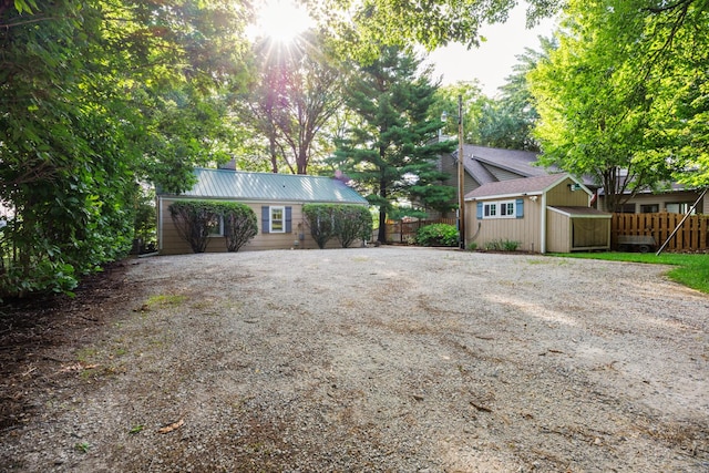 24503 Iroquois Ln, Hudson, IL 61748 - view of front of property with driveway, a storage shed, and a chimney
