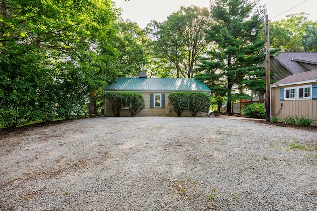 24503 Iroquois Ln, Hudson, IL 61748 - view of front of property featuring gravel driveway, a metal roof, and a chimney