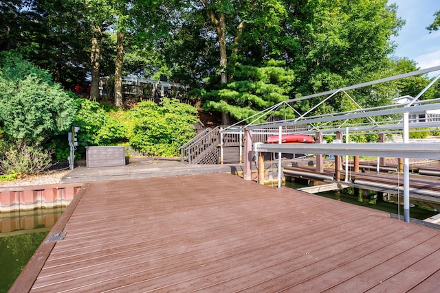 24503 Iroquois Ln, Hudson, IL 61748 - dock area featuring stairs, a wooden deck, and view of wooded area