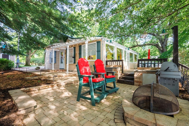24503 Iroquois Ln, Hudson, IL 61748 - view of patio with a fire pit, a wooden deck, exterior kitchen, and a pergola
