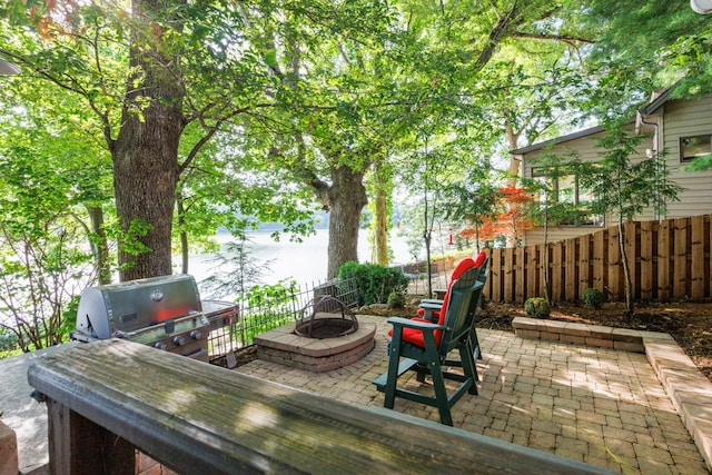 24503 Iroquois Ln, Hudson, IL 61748 - view of patio / terrace featuring an outdoor fire pit, grilling area, and a water view