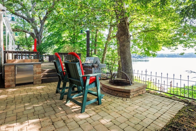 24503 Iroquois Ln, Hudson, IL 61748 - view of patio with a water view, a fire pit, and exterior kitchen