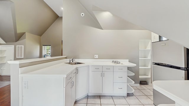 570 Hathaway Cir, Lake Forest, IL 60045 - kitchen with a peninsula, light countertops, freestanding refrigerator, white cabinets, and light tile patterned floors