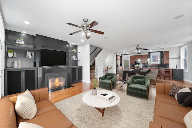 2864 N Riverwalk Dr, Chicago, IL 60618 - living room with a ceiling fan, recessed lighting, stairway, light wood-style flooring, and a tile fireplace
