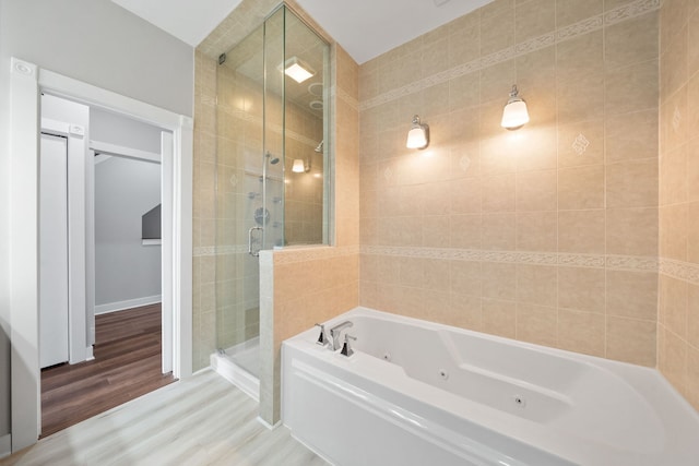 2864 N Riverwalk Dr, Chicago, IL 60618 - bathroom featuring a shower stall, a jetted tub, and wood finished floors