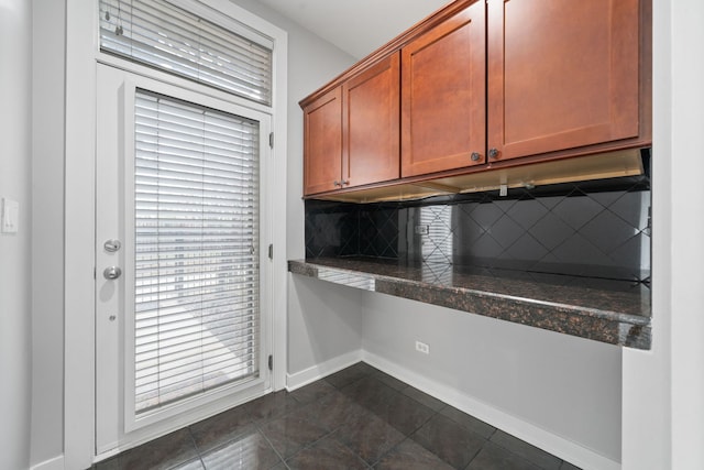 2864 N Riverwalk Dr, Chicago, IL 60618 - kitchen with decorative backsplash, built in study area, tile countertops, and dark tile patterned floors