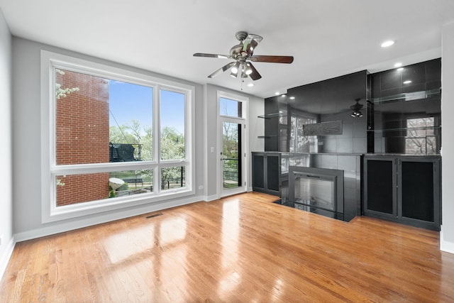 2864 N Riverwalk Dr, Chicago, IL 60618 - unfurnished living room featuring ceiling fan, wood finished floors, a fireplace with flush hearth, and recessed lighting