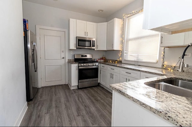 5523 W Huron St, Chicago, IL 60644 - kitchen featuring stainless steel appliances, white cabinetry, dark wood-style flooring, and light stone countertops