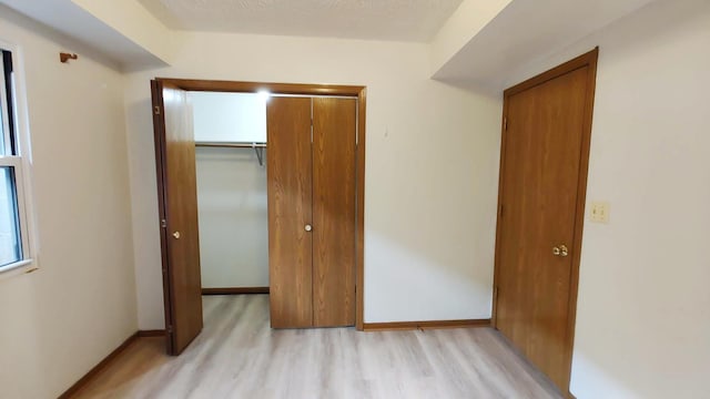 222 W 26th St Unit 202, Chicago, IL 60616 - unfurnished bedroom with light wood finished floors and a closet