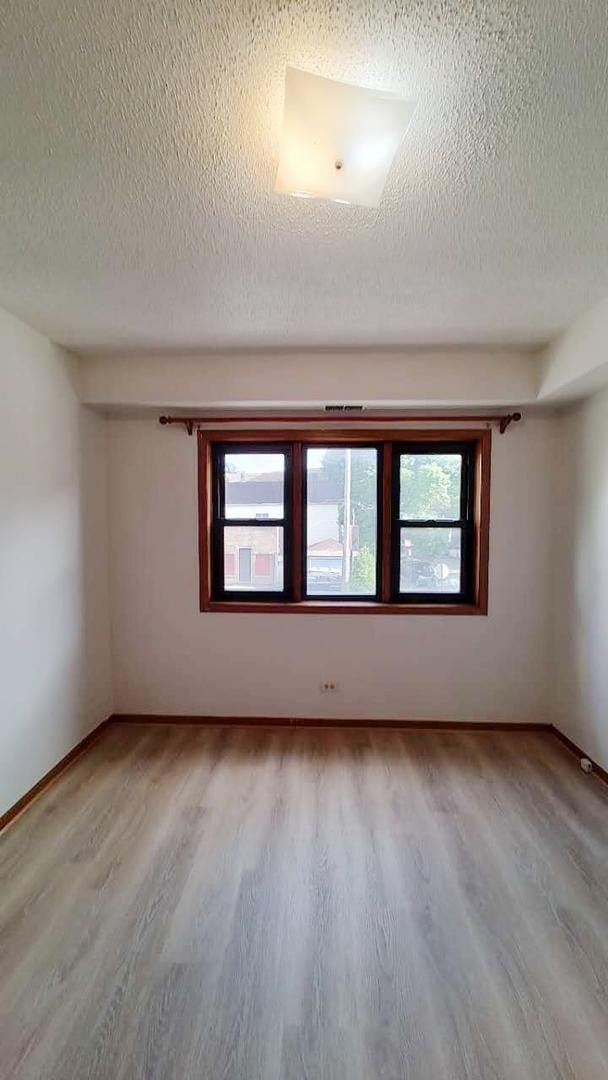 222 W 26th St Unit 202, Chicago, IL 60616 - unfurnished room with a textured ceiling and light wood finished floors