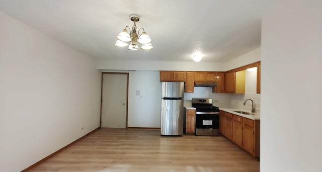 222 W 26th St Unit 202, Chicago, IL 60616 - kitchen featuring stainless steel appliances, under cabinet range hood, a chandelier, light countertops, and brown cabinets