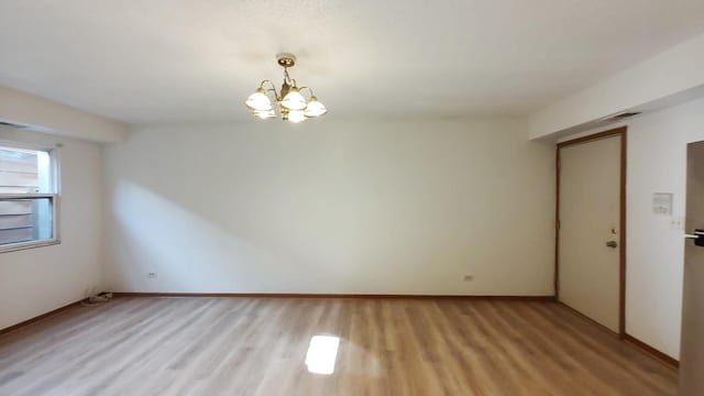 222 W 26th St Unit 202, Chicago, IL 60616 - unfurnished room featuring light wood finished floors and a chandelier