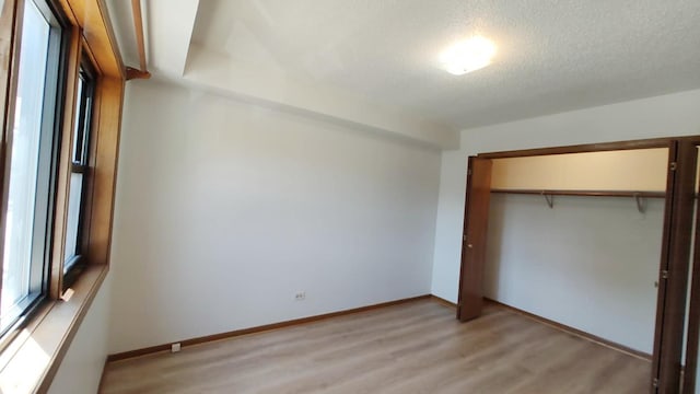 222 W 26th St Unit 202, Chicago, IL 60616 - unfurnished bedroom with light wood-style flooring, a closet, and a textured ceiling