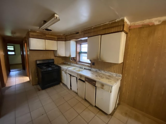 9221 S Normal Ave, Chicago, IL 60620 - kitchen featuring black gas range oven, light countertops, white cabinetry, wood walls, and light tile patterned floors