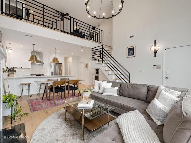2026 W Pierce Ave Unit 7, Chicago, IL 60622 - living area with stairs, light wood-style flooring, a chandelier, a high ceiling, and recessed lighting