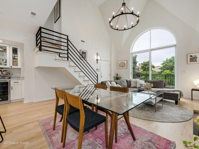 2026 W Pierce Ave Unit 7, Chicago, IL 60622 - dining space featuring beverage cooler, high vaulted ceiling, stairs, light wood-type flooring, and a chandelier