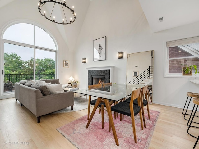 2026 W Pierce Ave Unit 7, Chicago, IL 60622 - living area featuring high vaulted ceiling, a high end fireplace, light wood-style floors, a chandelier, and healthy amount of natural light