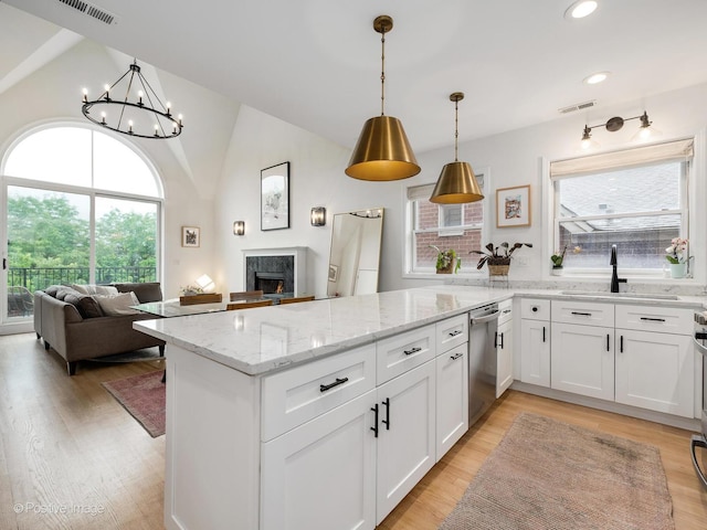 2026 W Pierce Ave Unit 7, Chicago, IL 60622 - kitchen featuring a peninsula, vaulted ceiling, a fireplace, white cabinetry, and healthy amount of natural light