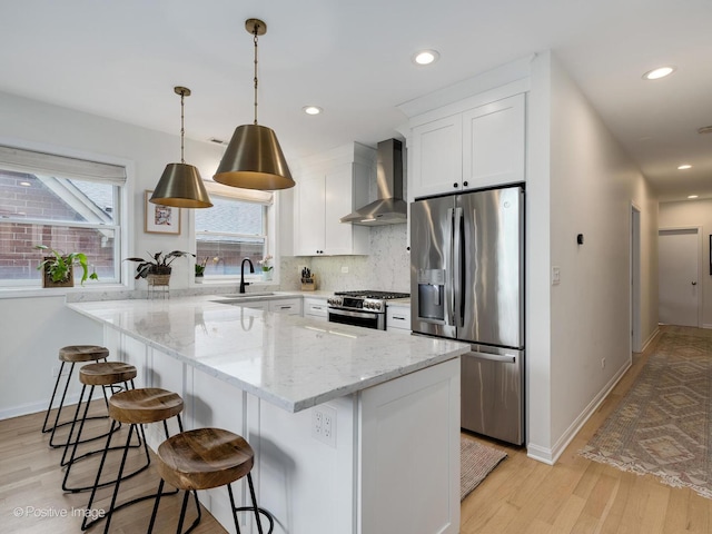 2026 W Pierce Ave Unit 7, Chicago, IL 60622 - kitchen featuring stainless steel appliances, wall chimney range hood, light wood-type flooring, tasteful backsplash, and white cabinetry