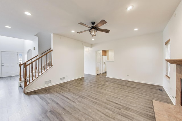 31692 N Clearwater Dr, Lakemoor, IL 60051 - unfurnished living room featuring ceiling fan, stairs, wood finished floors, recessed lighting, and arched walkways