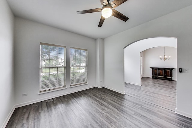 31692 N Clearwater Dr, Lakemoor, IL 60051 - empty room with wood finished floors, ceiling fan, arched walkways, and a chandelier