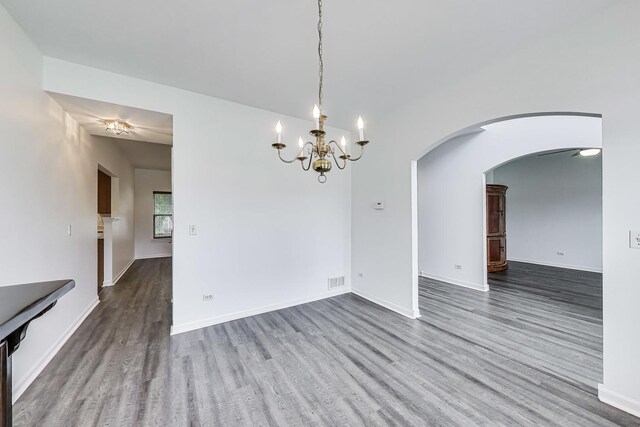 31692 N Clearwater Dr, Lakemoor, IL 60051 - unfurnished dining area with wood finished floors, arched walkways, and a chandelier