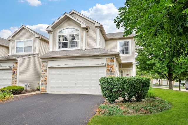 1934 Stoneheather Ave, Aurora, IL 60503 - view of front of property with driveway, an attached garage, stone siding, and a shingled roof