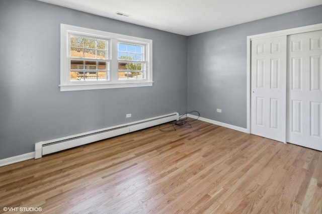 323 Marshall Rd, Bensenville, IL 60106 - unfurnished bedroom featuring a baseboard radiator, light wood finished floors, and a closet