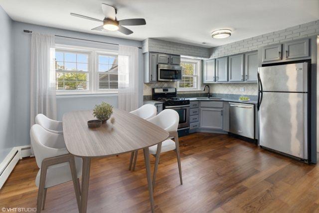 323 Marshall Rd, Bensenville, IL 60106 - kitchen with appliances with stainless steel finishes, gray cabinetry, a baseboard heating unit, dark wood-type flooring, and ceiling fan