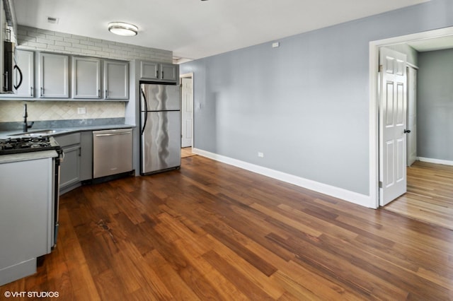 323 Marshall Rd, Bensenville, IL 60106 - kitchen featuring stainless steel appliances, gray cabinets, decorative backsplash, and dark wood-style flooring